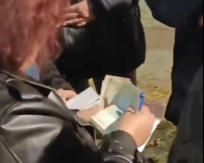“Podela ćaci dnevnica” – Žena drži spisak i novac, oko nje se okupili ljudi: “Bili su toliko zagledani u pare da 7 minuta nisu primetili da ih snimam”